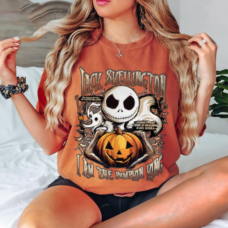 Puede incluir: Camiseta naranja con Jack Skellington de The Nightmare Before Christmas. El dise&ntilde;o incluye la cara de Jack, una calabaza y el texto "I Am The Pumpkin King". Texto adicional: "Christmas Time is Buzzing in My Skull."