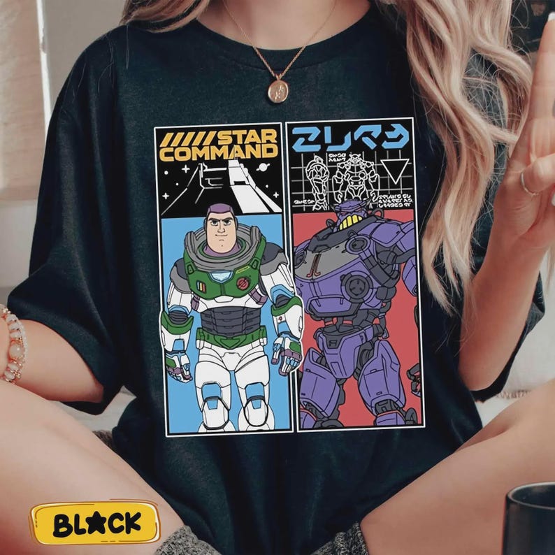 May include: Black t-shirt with a graphic of two characters from a science fiction movie. One character is in a green and white spacesuit, and the other is a purple robot. The shirt has the words "STAR COMMAND" and Japanese text.