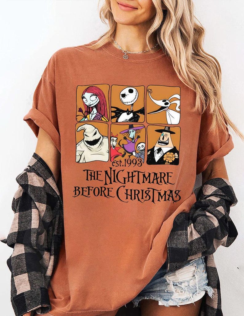 May include: Rust-colored t-shirt featuring a grid of six character portraits from "The Nightmare Before Christmas," including Sally and Jack Skellington. The text "est. 1993" and "THE NIGHTMARE BEFORE CHRISTMAS" are printed below the grid.
