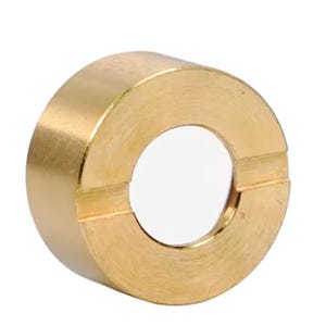 Puede incluir: Un anillo de latón macizo con una abertura circular. El anillo tiene forma cilíndrica con una superficie lisa y pulida. El latón tiene un color dorado cálido y la abertura es de un blanco brillante.