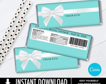 May include: Three rectangular candy bar wrappers in turquoise with a white horizontal stripe and a large white bow. The front features the text CHLOE & CO. The back includes a nutritional facts label with text and a barcode. Two black and white polka dot paper straws are positioned to the left of the wrappers.