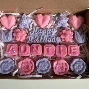 May include: A decorative gift box containing pink and lilac wax melts in heart, flower, and rose shapes. The phrase "Happy Birthday Auntie" is displayed in the center of the box.