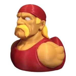 Puede incluir: Figura impresa en 3D de un luchador, con un pañuelo rojo, bigote amarillo y camiseta sin mangas roja. La figura tiene una complexión musculosa y está en una pose dinámica, mostrando el look icónico.
