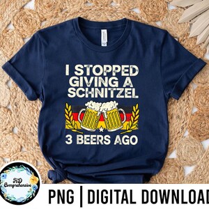 May include: Navy blue t-shirt with the text "I STOPPED GIVING A SCHNITZEL 3 BEERS AGO". The design includes two beer mugs with foam and the German flag colors. The shirt is a digital download.