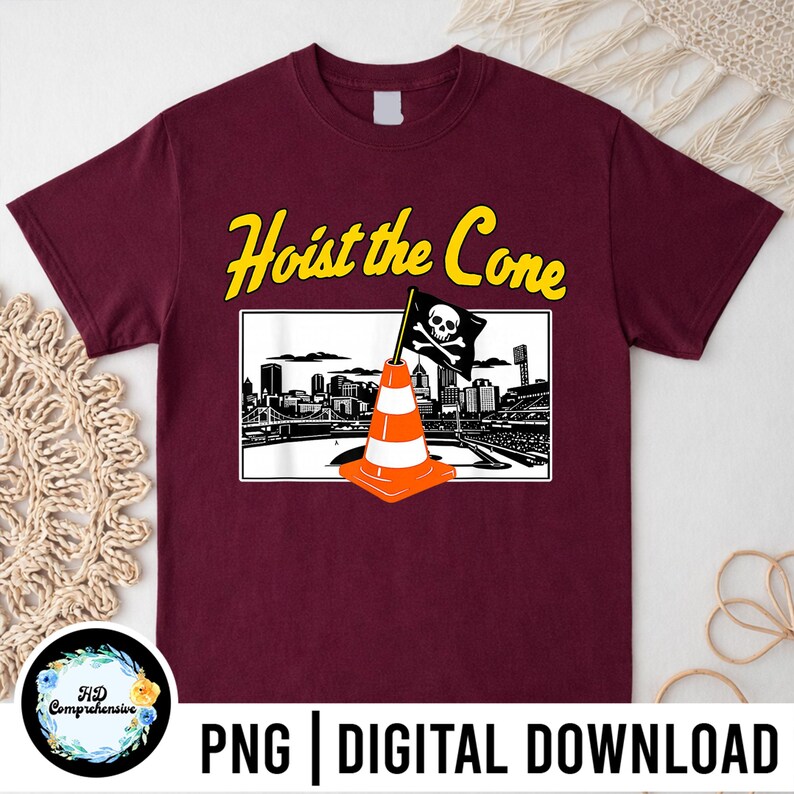 Puede incluir: Camiseta burdeos con la frase "Hoist the Cone" en amarillo. El dise&ntilde;o incluye un cono de tr&aacute;fico con una bandera de calavera y huesos cruzados, sobre un horizonte urbano. El texto "PNG | DIGITAL DOWNLOAD" est&aacute; en la parte inferior.