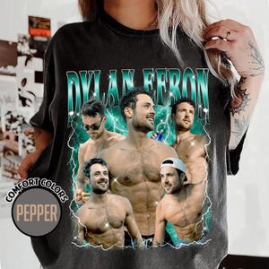 May include: Black t-shirt with a graphic of a man and the text "DYLAN EFRON" in teal. The shirt has a vintage style with the words "COMFORT COLORS" and "PEPPER" printed on the bottom left.