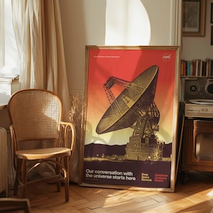 May include: A framed poster with a NASA graphic of a large radio telescope against a red and orange gradient background. The text "Our conversation with the universe starts here" is at the bottom. The poster is in a room with a wooden chair.