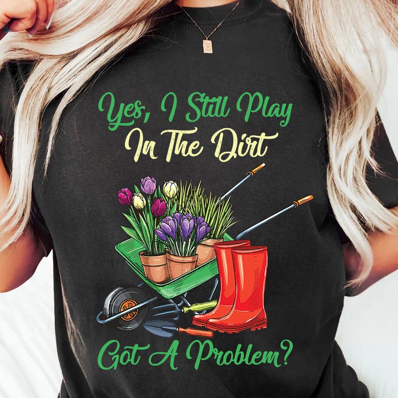 a woman wearing a black shirt that says yes i still play on the dirt got