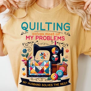 May include: A yellow t-shirt with a sewing machine and a quilt design. The text on the shirt reads "Quilting solves most of my problems. My husband solves the rest."