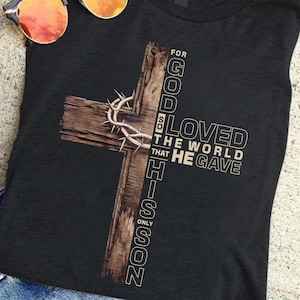 May include: A black t-shirt with a brown wooden cross and the text "For God So Loved The World That He Gave His Only Son".