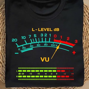 May include: Black t-shirt with a graphic of a VU meter with the text "L-LEVEL dB" and "VU". The meter is red, yellow, and blue with a needle pointing to the right. The bottom of the shirt has a smaller graphic of a sound level meter with numbers from -20 to +4.