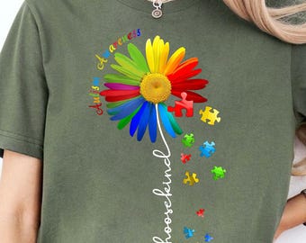 May include: Olive green t-shirt featuring a colorful sunflower with rainbow petals and a yellow center. The design includes puzzle pieces and the words "Autism Awareness" and "choosekind" in white script.