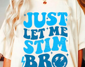 May include: White t-shirt with blue text that reads "Just Let Me Stim Bro" with a blue smiley face with lightning bolts for eyes.