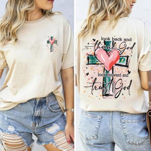 May include: Beige t-shirt with a cross and heart graphic. The front features a small cross and heart design, while the back displays a larger cross and heart with the text "look back and thank God, look forward and trust God."