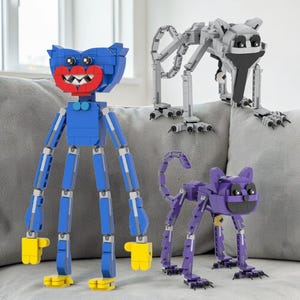 May include: Three toy figures constructed from blue, gray, and purple building blocks. The blue figure has a large red mouth and yellow hands and feet. The gray figure is in a crawling position. The purple figure resembles a cat.