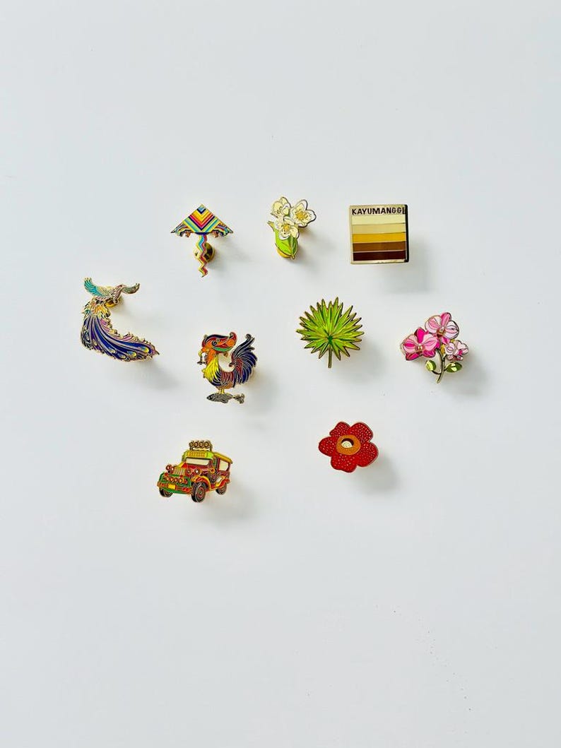 Puede incluir: Un conjunto de diez pines de esmalte que representan varios s&iacute;mbolos culturales filipinos, incluyendo un gallo, un jeepney, una flor, una palmera, una cometa, un pavo real y una flor. Los pines son todos de color dorado con detalles de esmalte de colores.