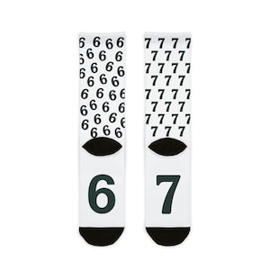 May include: White socks with black numbers. One sock has the number 6 repeated and the other has the number 7 repeated. The toes and heels are black. The socks are a fun and unique accessory.