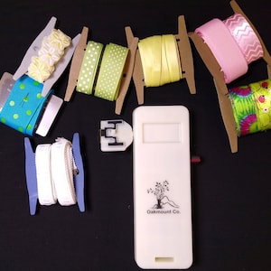 Enrouleur pour ruban, dentelle et bordure. Plus 12 cartes en ruban découpées. Fonctionne avec des piles multifonctionnelles pour organiser rapidement les fournitures de bricolage.