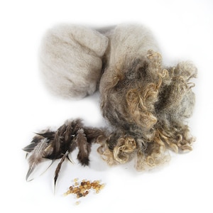 May include: A collection of crafting supplies including a ball of white wool, a clump of brown and white wool, a pile of brown feathers, and a scattering of small brown beads.
