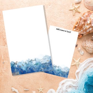 May include: Two blank notepads with a watercolor design of blue ocean waves and sea life, including fish, whales, and an octopus. The text "Add a name or text!" is written on the notepad on the right.