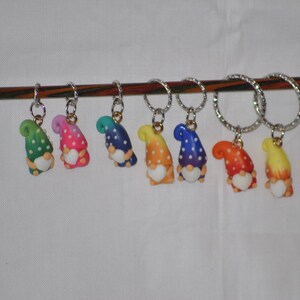 Puede incluir: Un conjunto de ocho marcadores de punto de gnome coloridos con lunares blancos. Cada marcador est&aacute; unido a un anillo plateado y tiene un coraz&oacute;n blanco en la parte delantera.