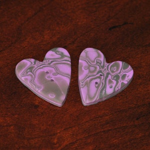May include: Two purple and gray heart-shaped buttons with a marbled pattern.