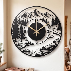 May include: A circular wall clock featuring a black metal cutout design of a mountain range, pine trees, and a winding river. The clock face is black with gold-colored hands and numerals at the 3, 6, 9, and 12 o'clock positions.