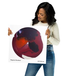May include: A square canvas print displaying an abstract artwork titled "Magenta Moonbase." The design is circular, with hues of red, magenta, and black on a white backdrop. The artist's name, KPS McLean, is printed below the artwork.