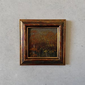 Könnte beinhalten: Gerahmtes kleines Landschaftsgemälde mit warmer Farbpalette. Das Kunstwerk zeigt eine Waldszene mit Herbstlaub in Rot-, Orange- und Gelbtönen. Der Rahmen ist dunkelbraun mit goldenen Akzenten.