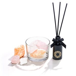 Könnte beinhalten: Aromatherapie-Set mit einer schwarzen Diffusorflasche, schwarzen Stäbchen und einer Schleife. Ein klares Glas enthält Kristalle und rohe Kristalle in Rosa, Orange und Weiß. Auf dem Glas steht "MY CANDLE HOME".