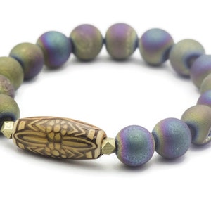May include: A bracelet made of iridescent agate beads with a brown and white patterned bead in the center.