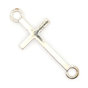 May include: Silver-toned cross charm with two jump rings for attaching to jewelry or other crafts.