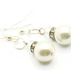 Peut inclure: Une paire de boucles d'oreilles en argent avec des accents de perles blanches et de cristal.