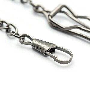 K&ouml;nnte beinhalten: Eine silberne Kette mit einem silbernen Verschluss und einem silbernen Haken. Die Kette besteht aus kleinen, miteinander verbundenen Ringen.