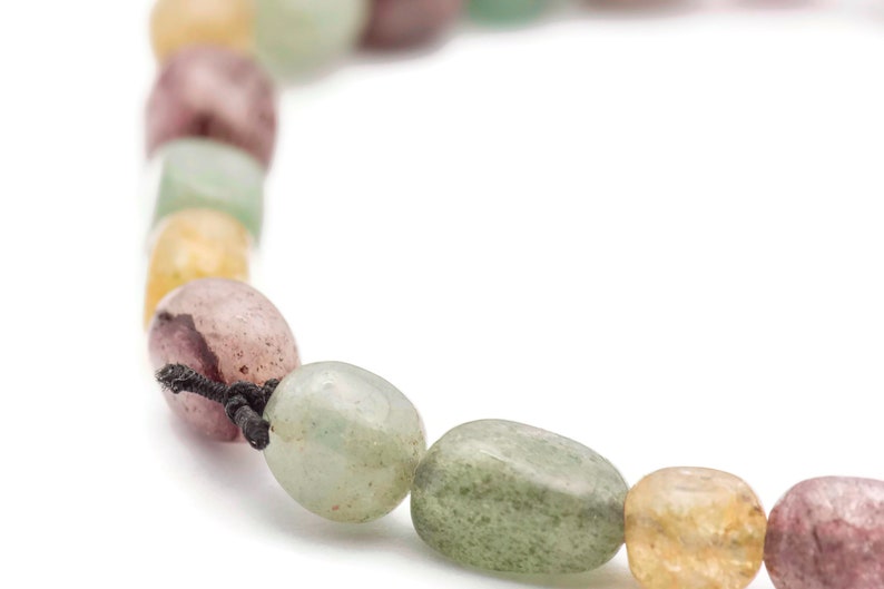 May include: A close-up of a multi-coloured beaded necklace with a black cord. The beads are a mix of green, pink, and yellow.