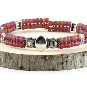 Button and Bows Raspberry Sorbet Cuff Memory Wire Bracelet on a wood piece with tree bark edging