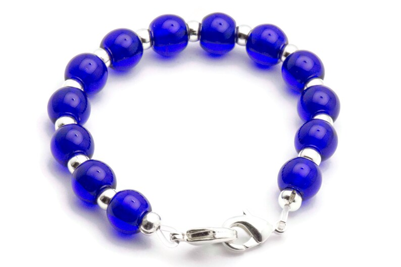 May include: A blue glass bead bracelet with silver spacers and a silver clasp.
