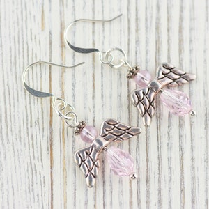 May include: A pair of silver angel wing earrings with pink crystal beads.