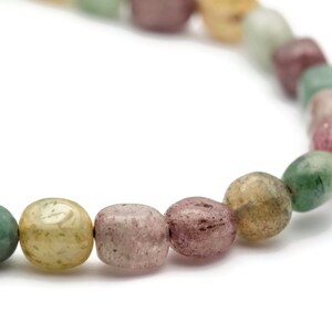 May include: A bracelet made of smooth, oval-shaped beads in shades of green, pink, and brown.