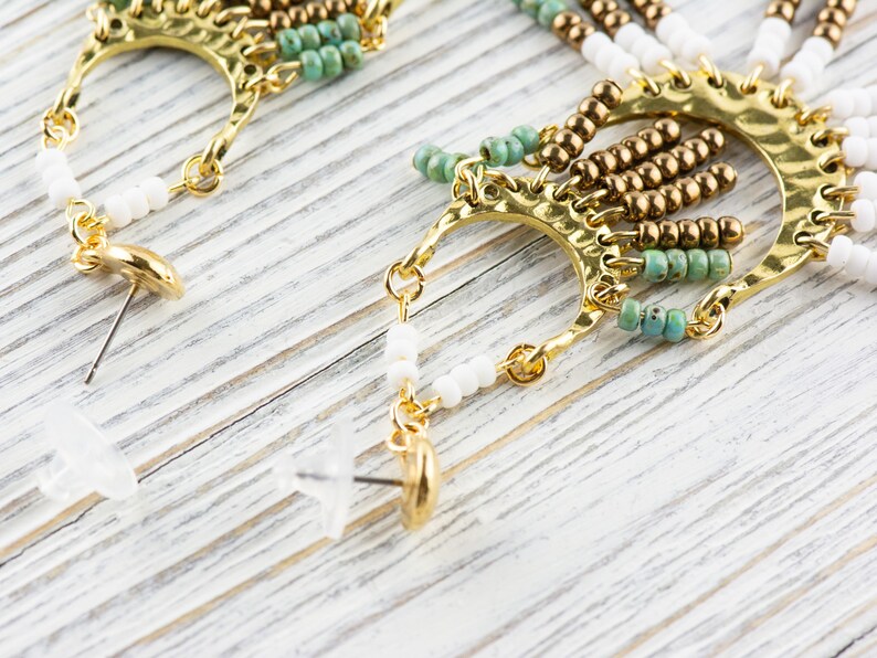 May include: A pair of gold tone earrings with turquoise and white beads, and a gold tone hook closure.