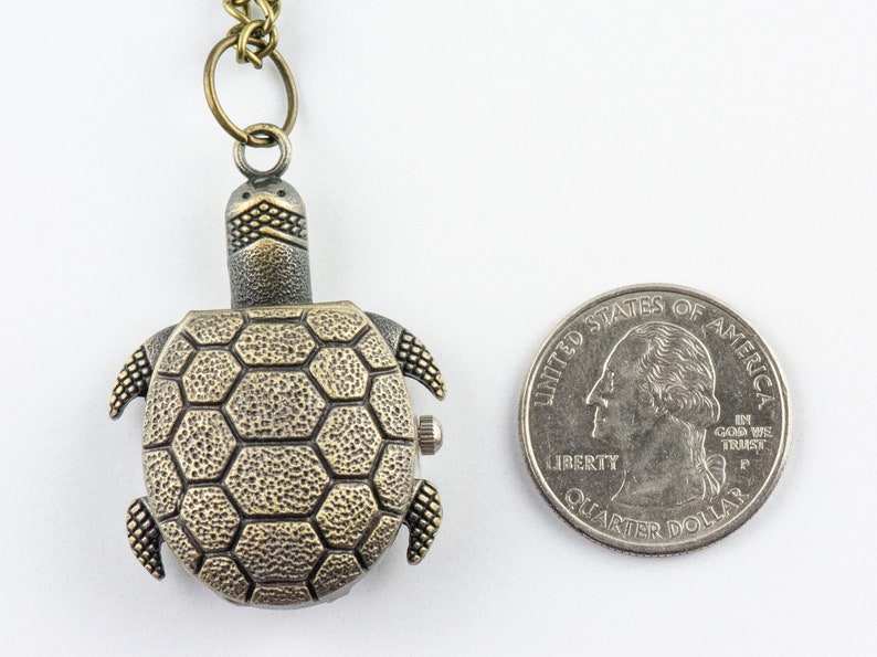 May include: A bronze turtle-shaped pocket watch with a chain. The watch is about the size of a quarter.