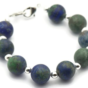 May include: A blue and green gemstone bracelet with silver beads and a silver clasp.