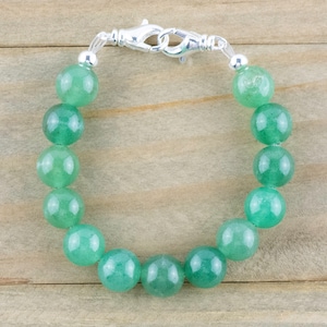 May include: A green jade stone bracelet with a silver clasp.