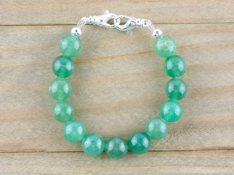 May include: A green jade stone bracelet with a silver clasp.