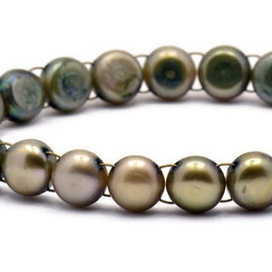 Op de afbeelding: Een armband gemaakt van groene parels met een bronzen vlinderbedel.