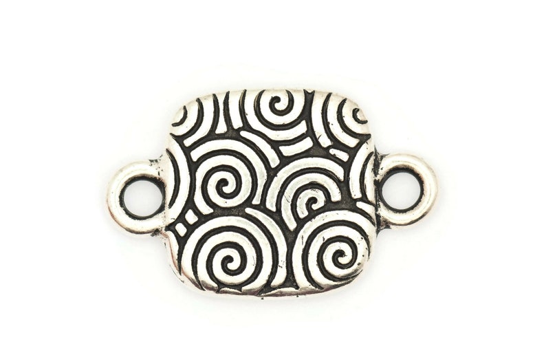 May include: Silver-toned metal connector with a square shape and a swirling pattern. The connector has two loops on either side.