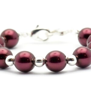May include: A burgundy pearl bracelet with silver beads and a silver clasp.