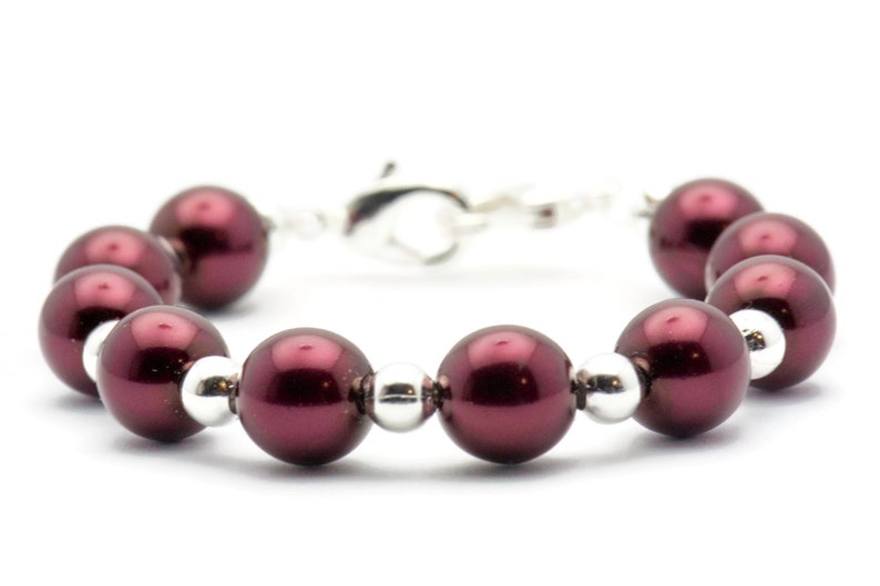 May include: A burgundy pearl bracelet with silver beads and a silver clasp.