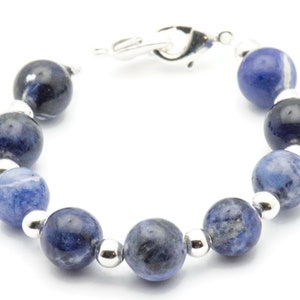 K&ouml;nnte beinhalten: Ein Armband aus blauen Edelsteinen mit silbernen Perlen und einem silbernen Verschluss.