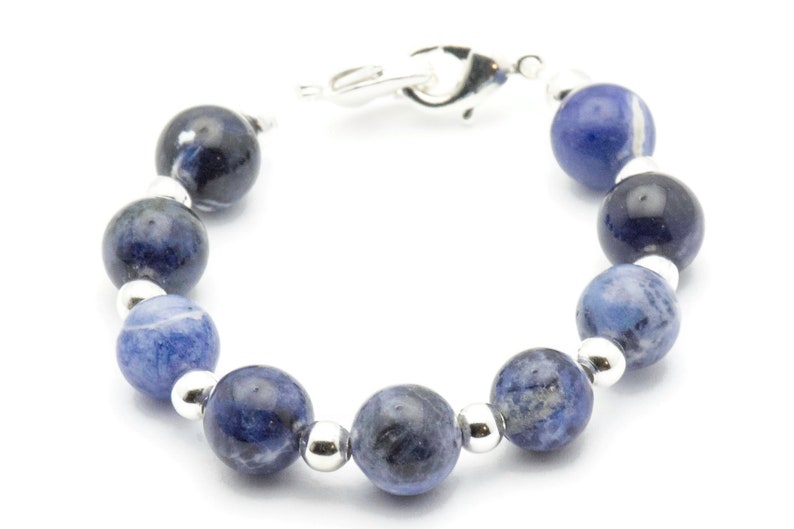 K&ouml;nnte beinhalten: Ein Armband aus blauen Edelsteinen mit silbernen Perlen und einem silbernen Verschluss.